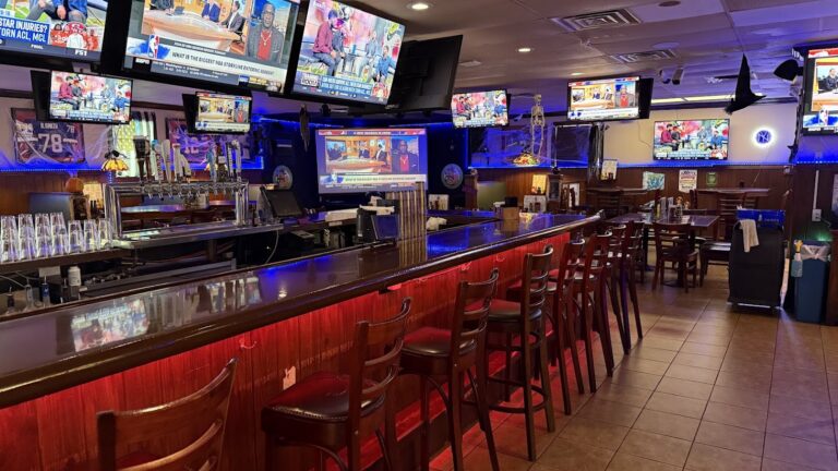 Packy’s Sports Pub interior with a long wooden bar, seating, and sports televisions