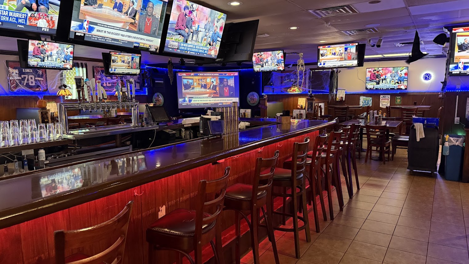 Packy’s Sports Pub interior with a long wooden bar, seating, and sports televisions